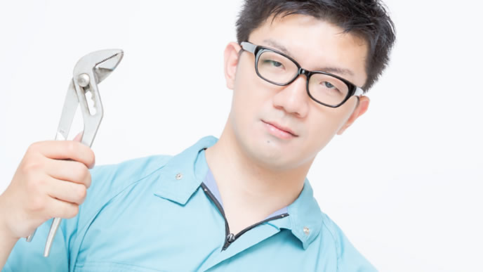 工具を持ち仁王立ちする工場作業員