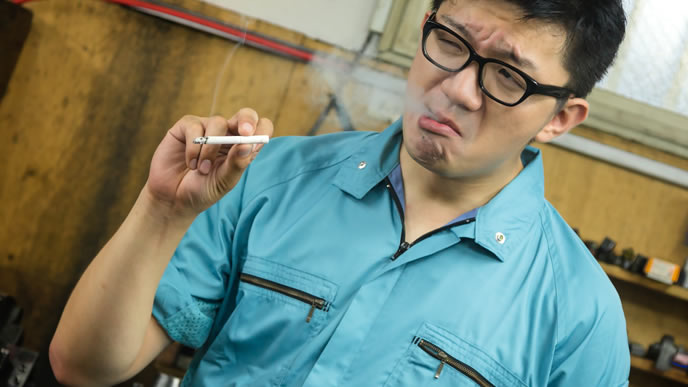 仕事が一段落つき一服をする工場作業員