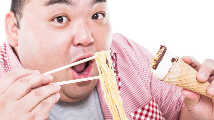 ラーメンとアイスを同時に食べる男性