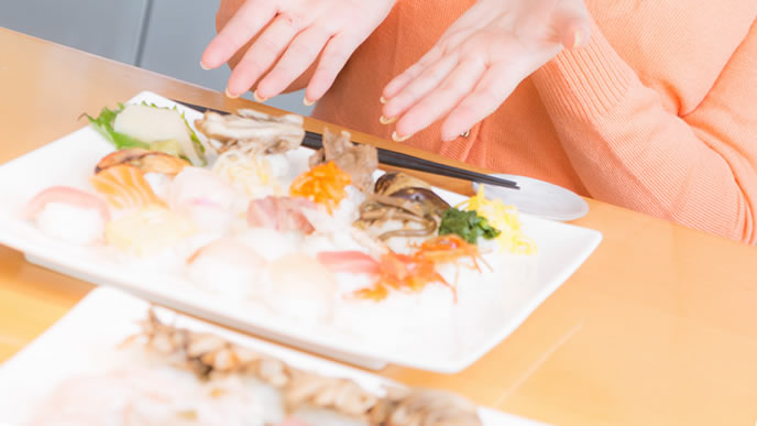 珍しい外食でお寿司を食べる女性