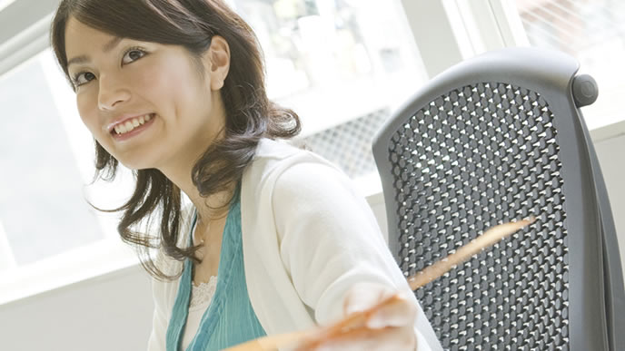 部下に書類を渡す女性管理職