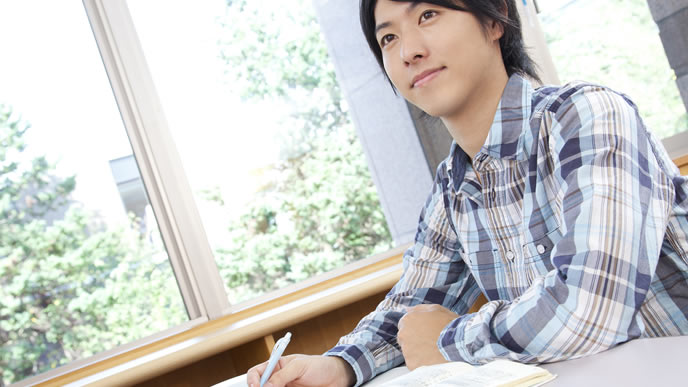 業界研究の仕方をメモする大学生
