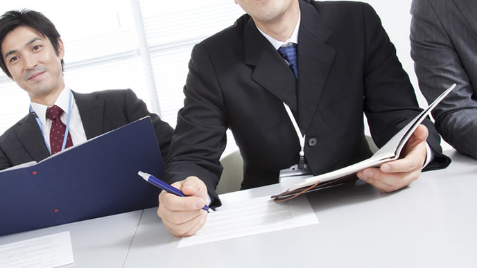応募者の書類を見ながら面接する担当者