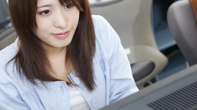 パソコンで企業に応募する女子大生