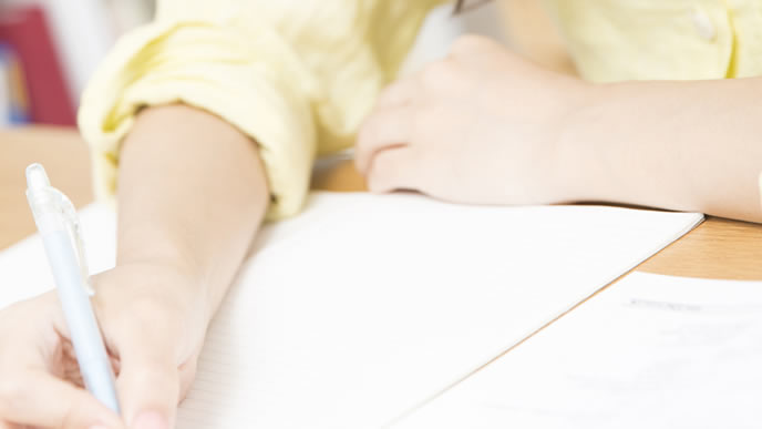 履歴書の下書きをする高校生