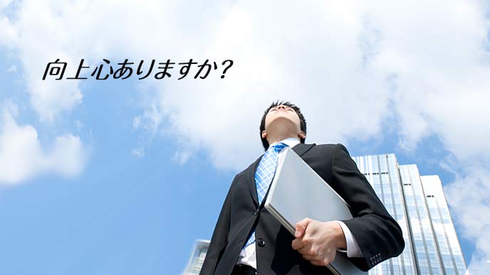 ビジネス街を上を見て歩く男性