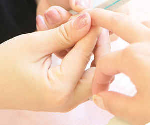 爪の状態を調べるネイリスト