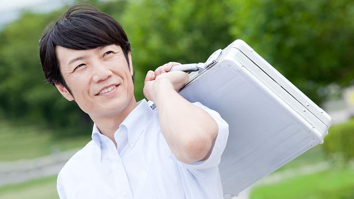 緑を背景に地方都市で仕事する男性