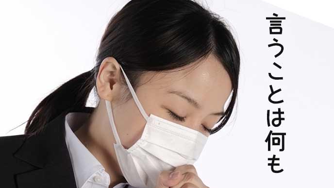 マスクをつけて目を伏せるリクルート服の女性