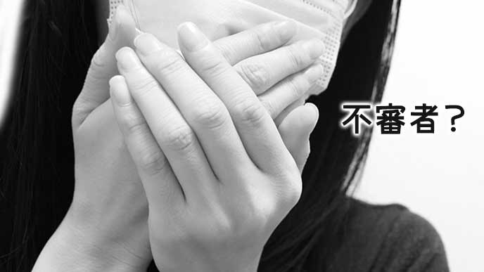 マスクをして顔を隠す女性