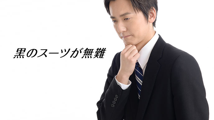 黒のスーツを着て顎に手をやる就活学生