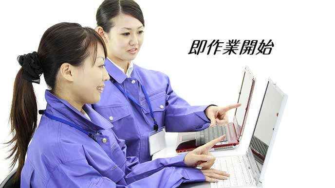 作業着でパソコンを操作する派遣社員