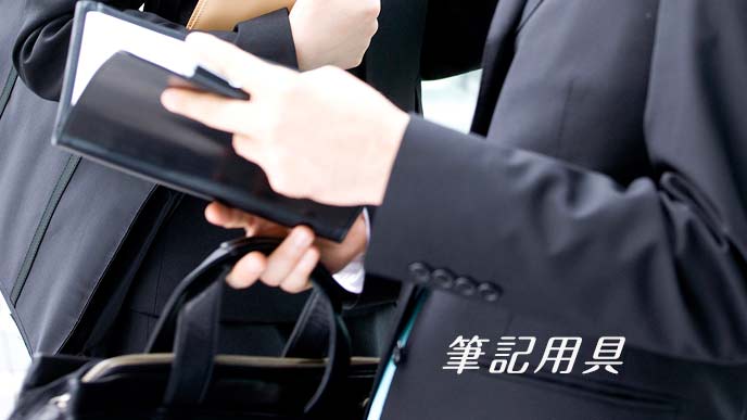 スケジュール帳を開いて見る面接者