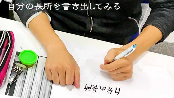 自分の長所を紙に書き出す学生