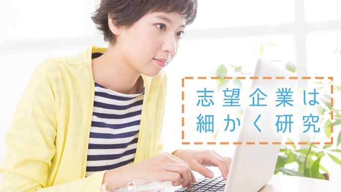 パソコンで志望する企業の事業内容や研究内容を調べている大学生