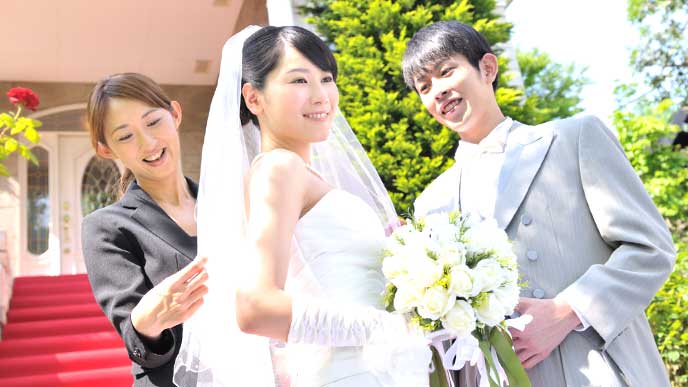結婚式場で新婦のドレスを手入れをするウエディングプランナー