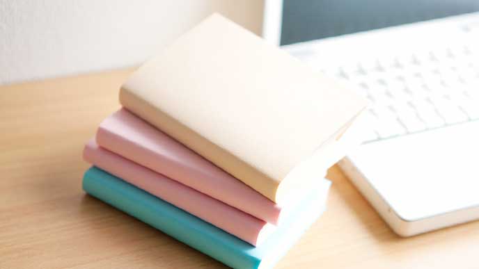 机に積みあがった就活用の書籍とパソコン