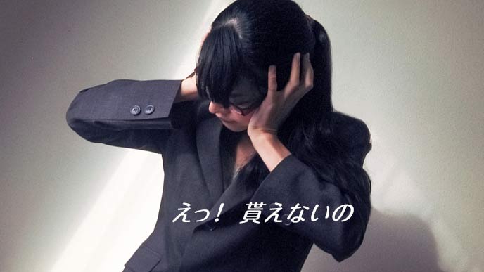 頭を抱えて嘆くスーツ姿の女性