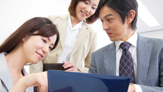 年下の先輩に仕事を教えてもらっている男性社員