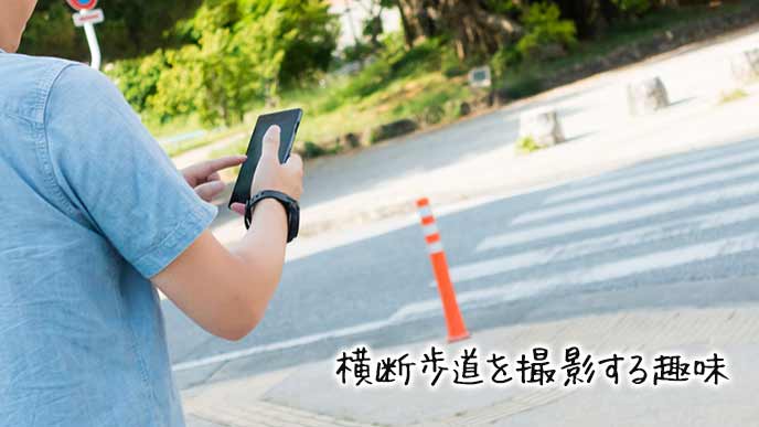 横断歩道をスマホで撮影する男性