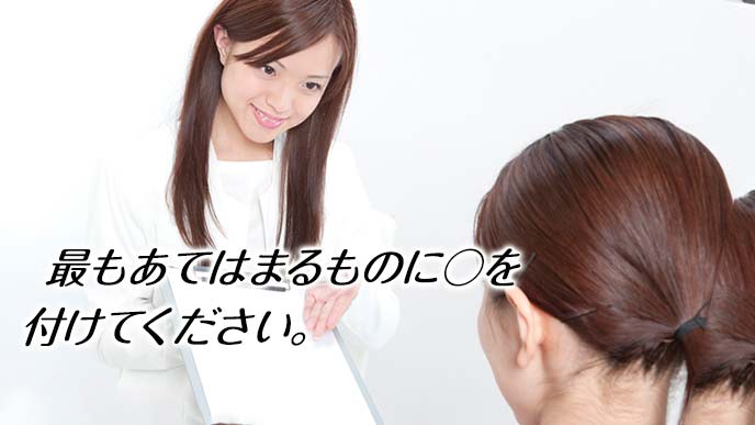 ストレスチェックの用紙を見せながら説明する女性