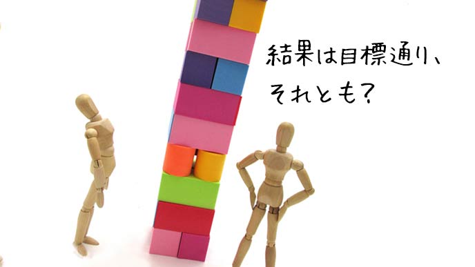 積み上げた積み木を見上げて評価する人物