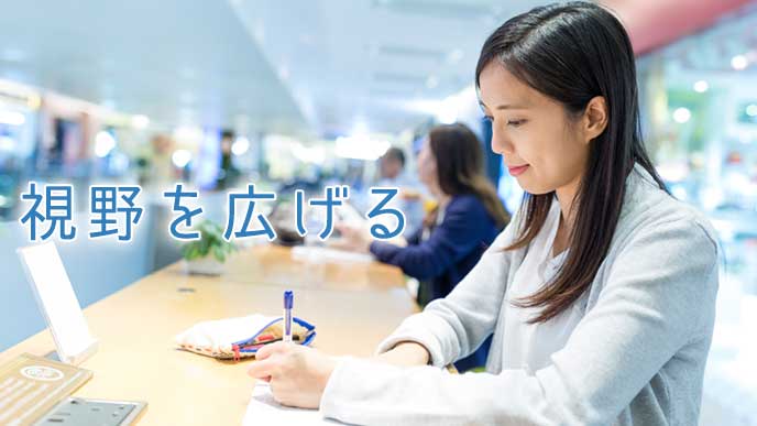 ノートにスケジュールを書く大学生