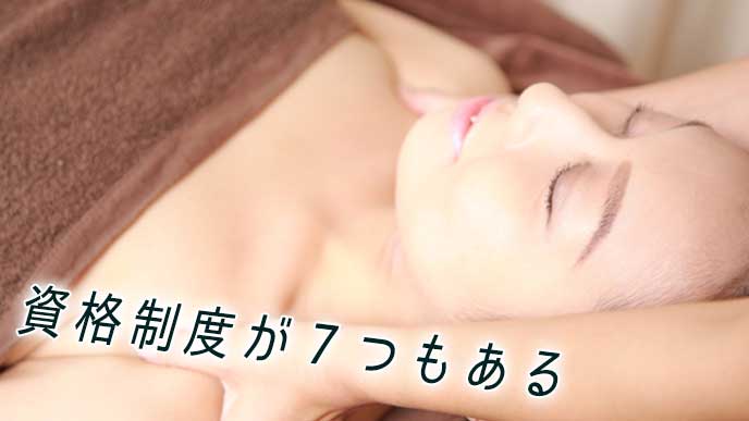 エステティシャンに肩をマッサージしてもらっている女性
