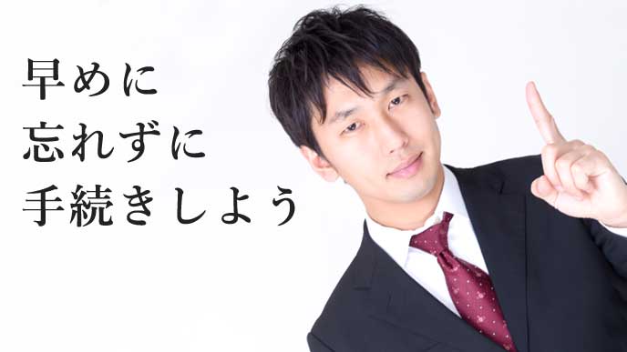 人差し指を立てるスーツ姿の男性
