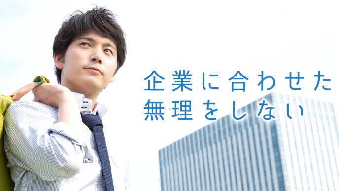 企業ビルを背景に歩くビジネスマン