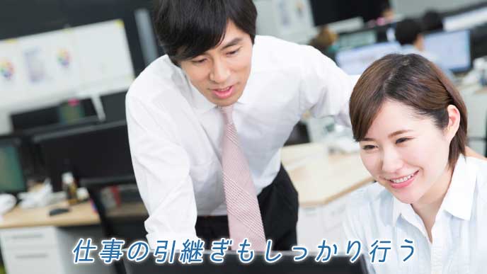 後輩に仕事の引継ぎを行うビジネスマン