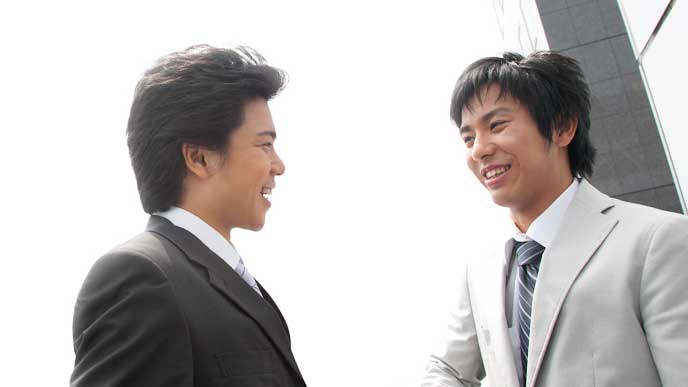 屋上で会話をする会社員達