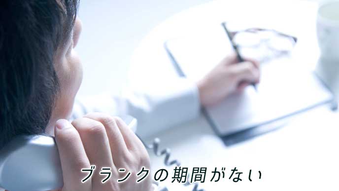 電話応対しながらメモをとるビジネスマン