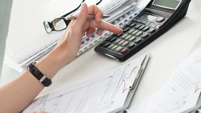 電卓で計算する経理事務の女性