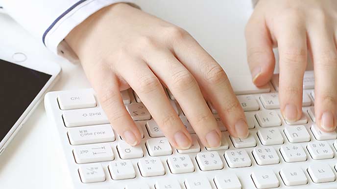 キーボードを打つ女性の手