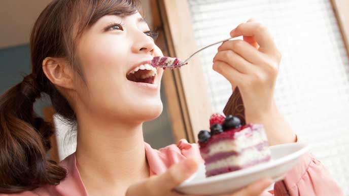 ケーキを美味しそうに食べる女性