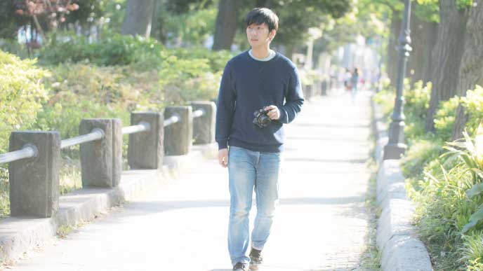 カメラを持って散歩をしている男性