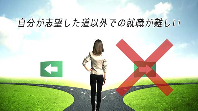 分かれ道を前に立ち止まる女性