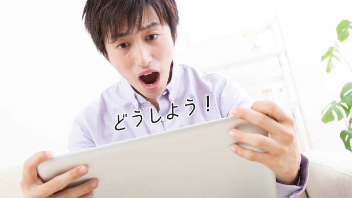 ノートパソコンを見て焦る大学生