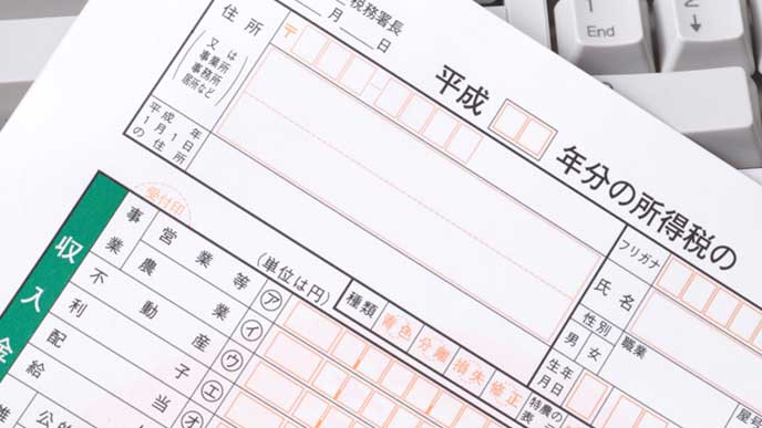 キーボードの上にある確定申告の書類
