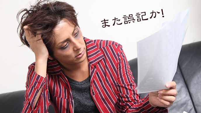 誤記入を発見して落ち込む男性