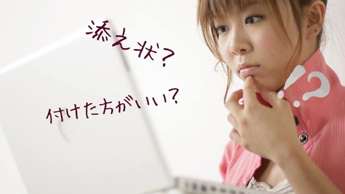 パソコンを見ながら添え状で悩む女性