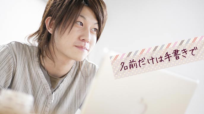 ラップトップで書き物する男子学生