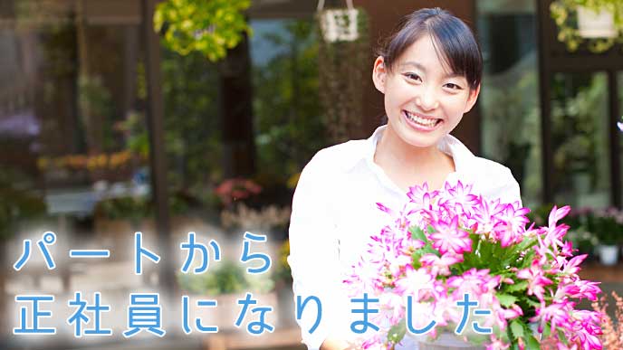 お花を持ちニッコリ微笑むフラワーショップの正社員