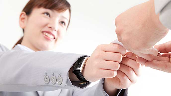 営業で取引先と名刺交換をする会社員の女性