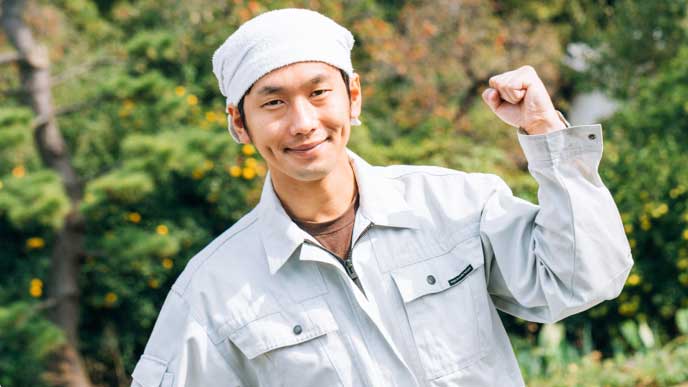 笑顔でガッツポーズを取っている農家