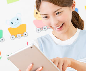 タブレットを見る保育士