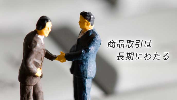 握手をしているビジネスマン達の人形