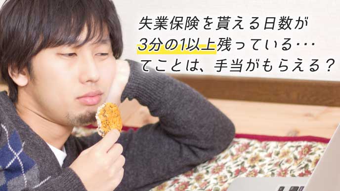 自宅で横になりながらせんべいを食べる男性
