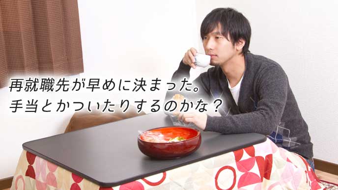 こたつに入りお茶を飲みながら、お菓子を食べる男性